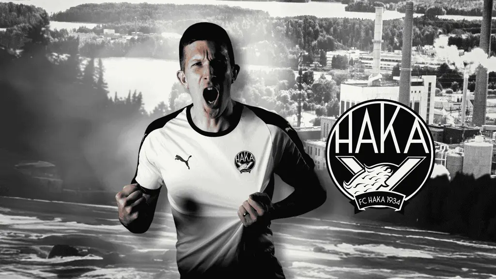 FC Hakan pelaaja innoissaan, mustavalkoinen kuva Valkeakoskesta taustalla ja FC Hakan logo