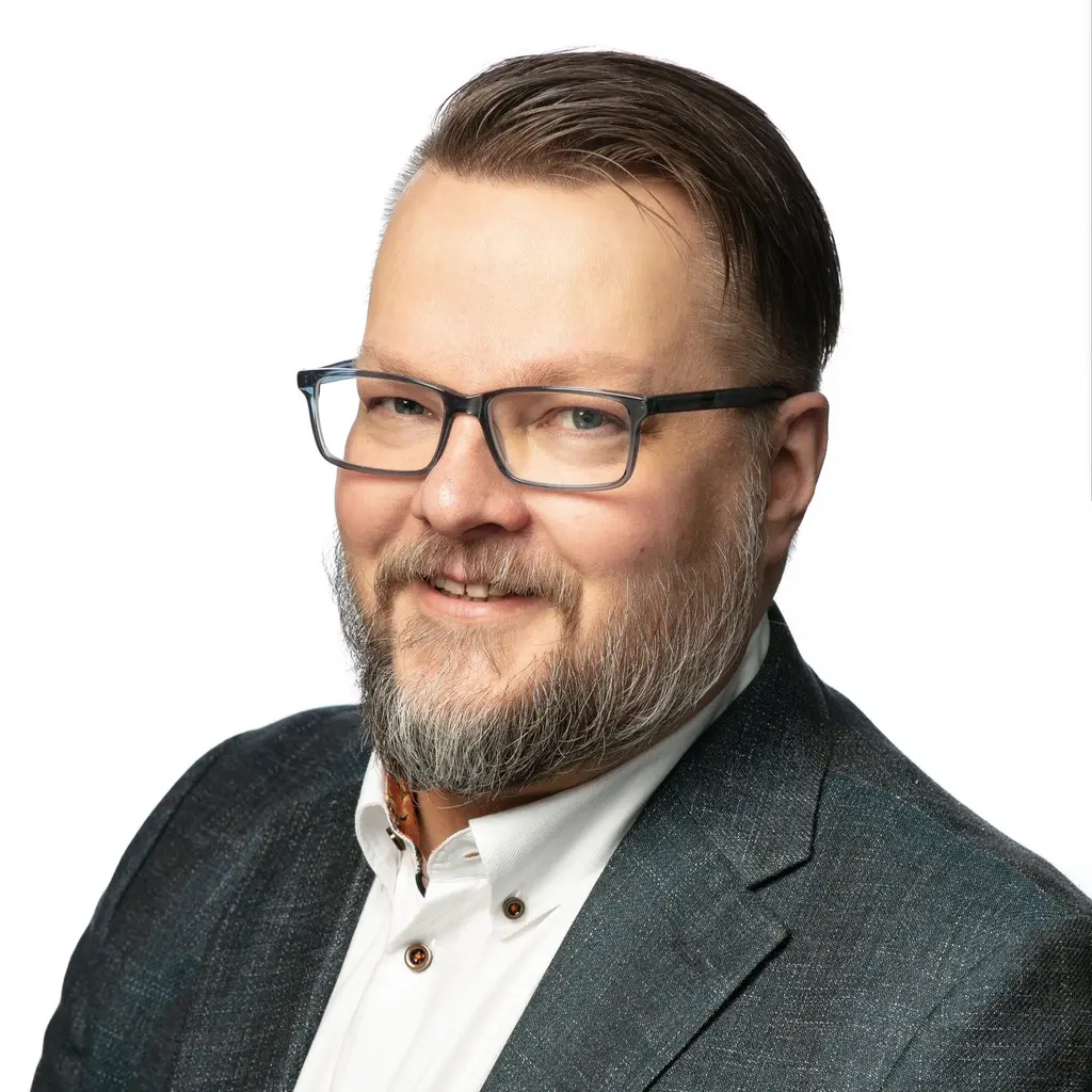 Mies katsoo kameraan hymyillen