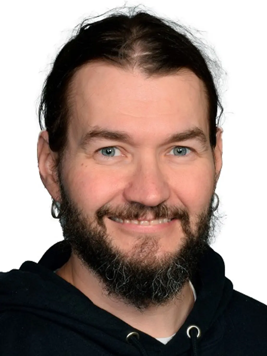 Mies katsoo kameraan hymyillen