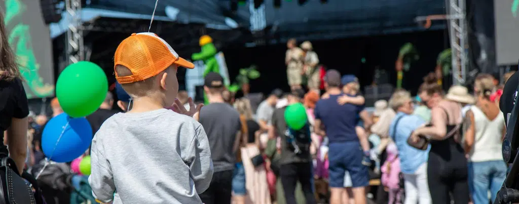 Lapsi sinisen ilmapallon kanssa Mustakari Memories -lastepäivässä 2024.