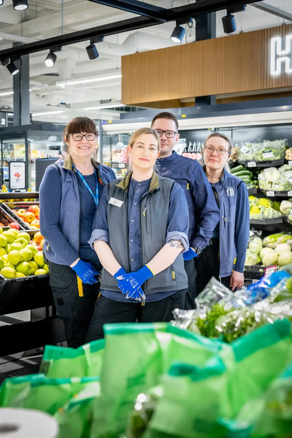 Neljä S-market Oitin työntekijää katsoo hymyillen kameraan.