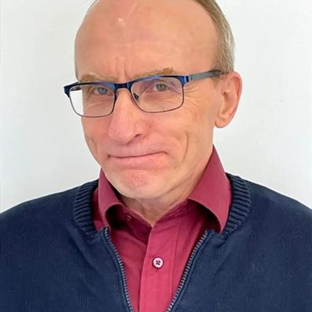 Mies katsoo kameraan hymyillen