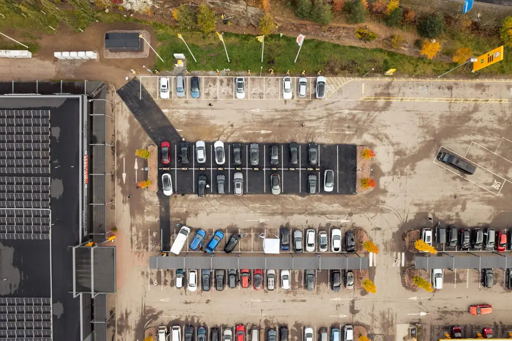 Ilmakuva ABC-aseman pysäköintialueesta ja sähköautojen latauskentästä.