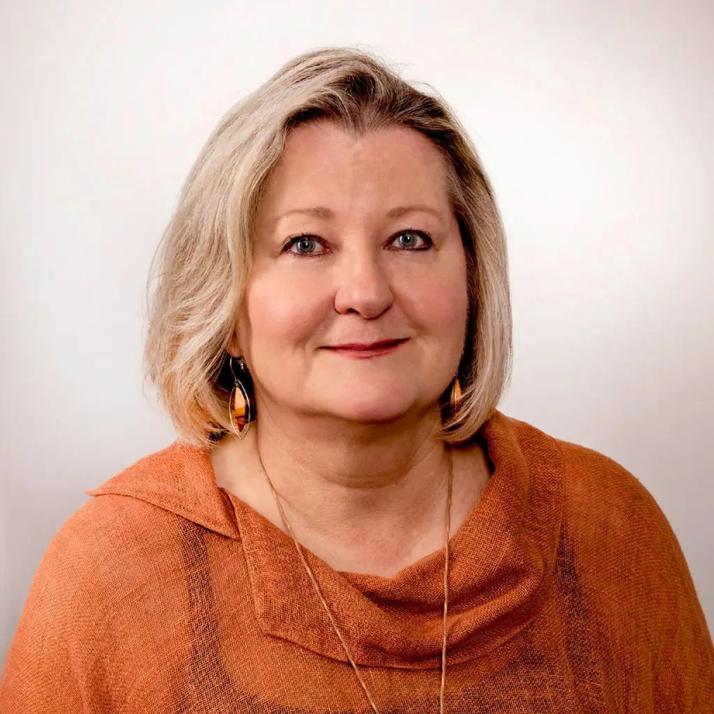 Nainen katsoo kameraan hymyillen