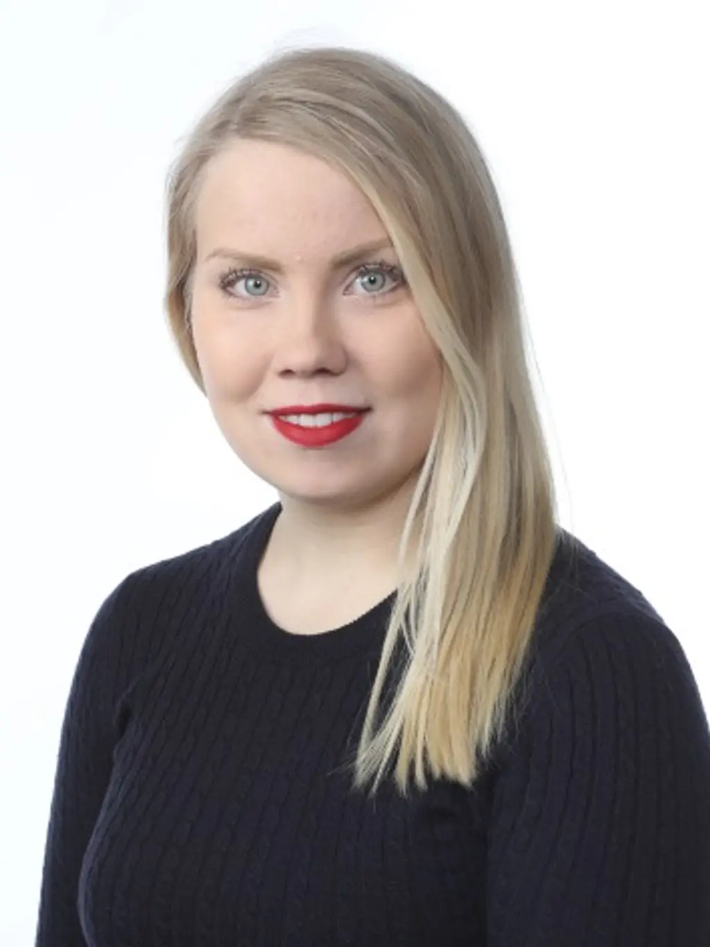 Nainen katsoo hymyillen kameraan