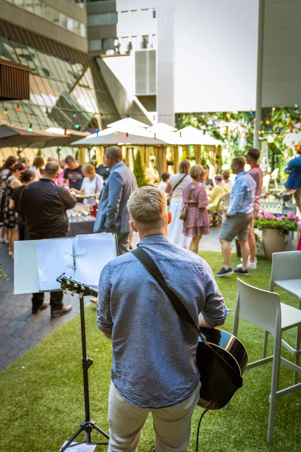 Muusikko soittaa kitaraa yleisön edessä.