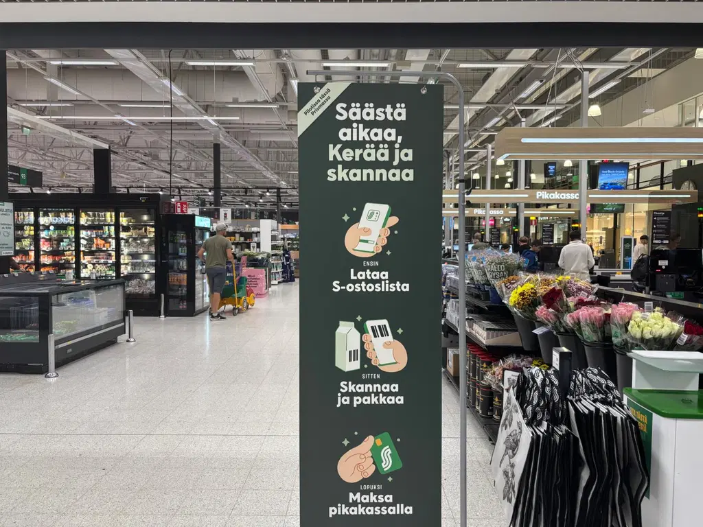 Kerää ja skannaa -palvelun myymäläjuliste pikakassojen vieressä.