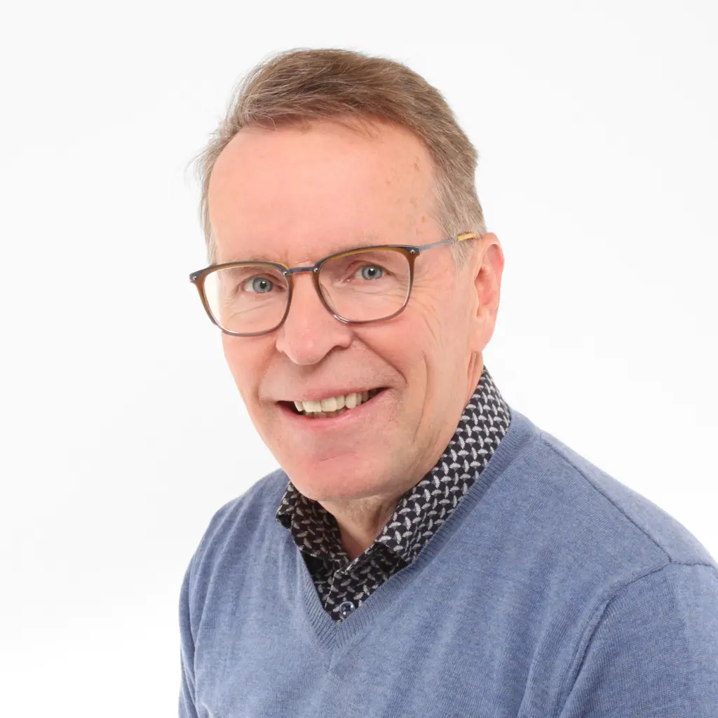 Mies katsoo kameraan hymyillen