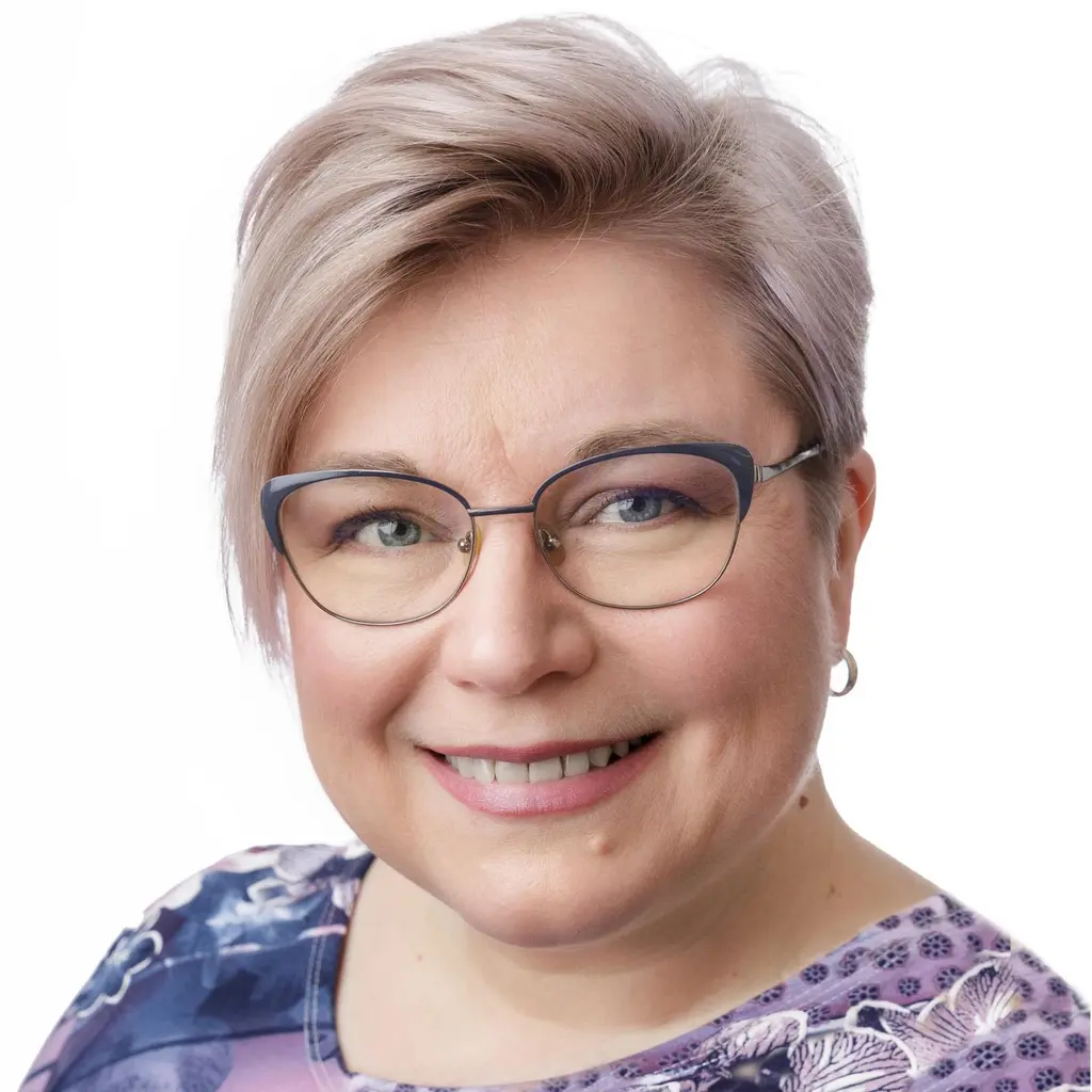 Nainen katsoo kameraan hymyillen