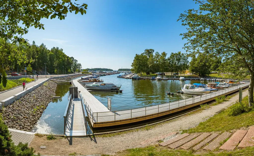 Laituri ja veneitä pienessä metsien ympäröimässä satamassa