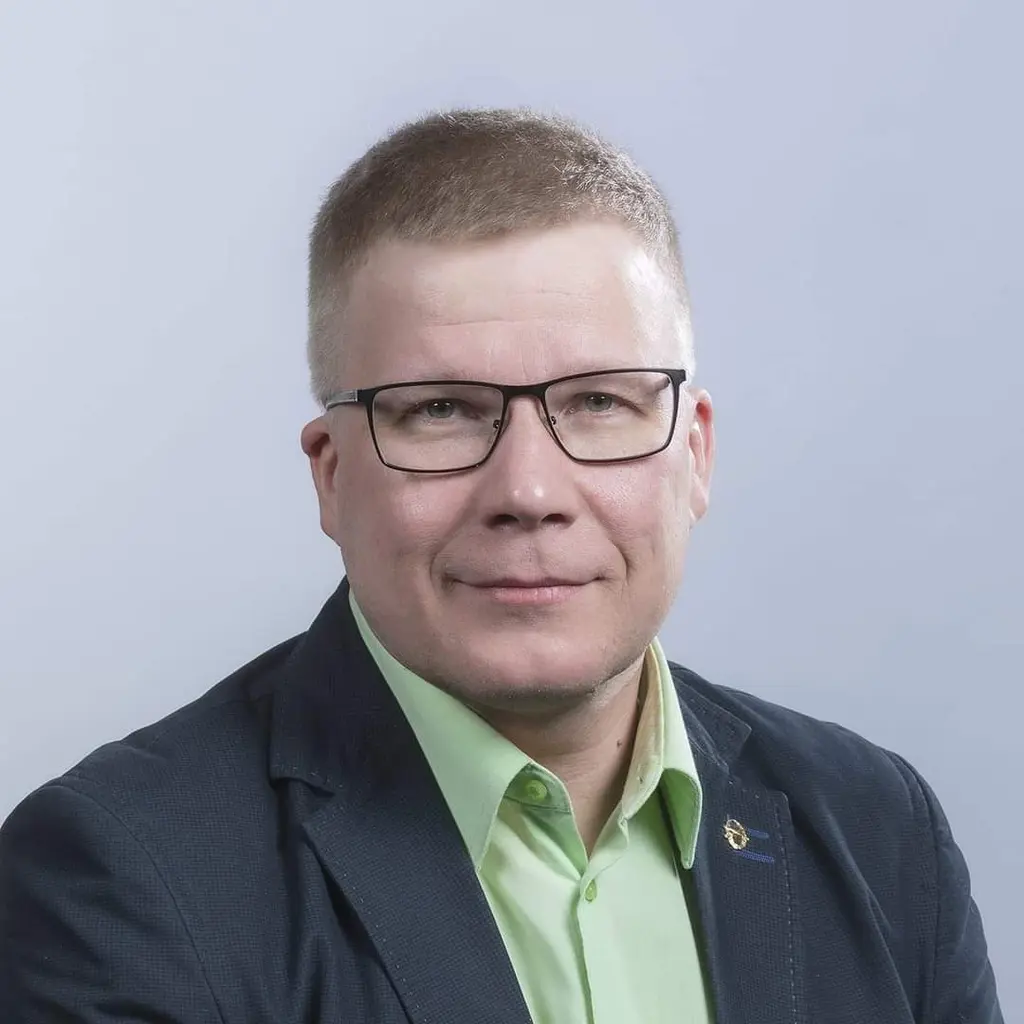Mies katsoo kameraan hymyillen