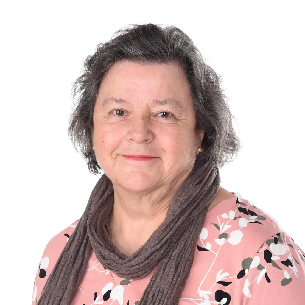 Nainen katsoo kameraan hymyillen