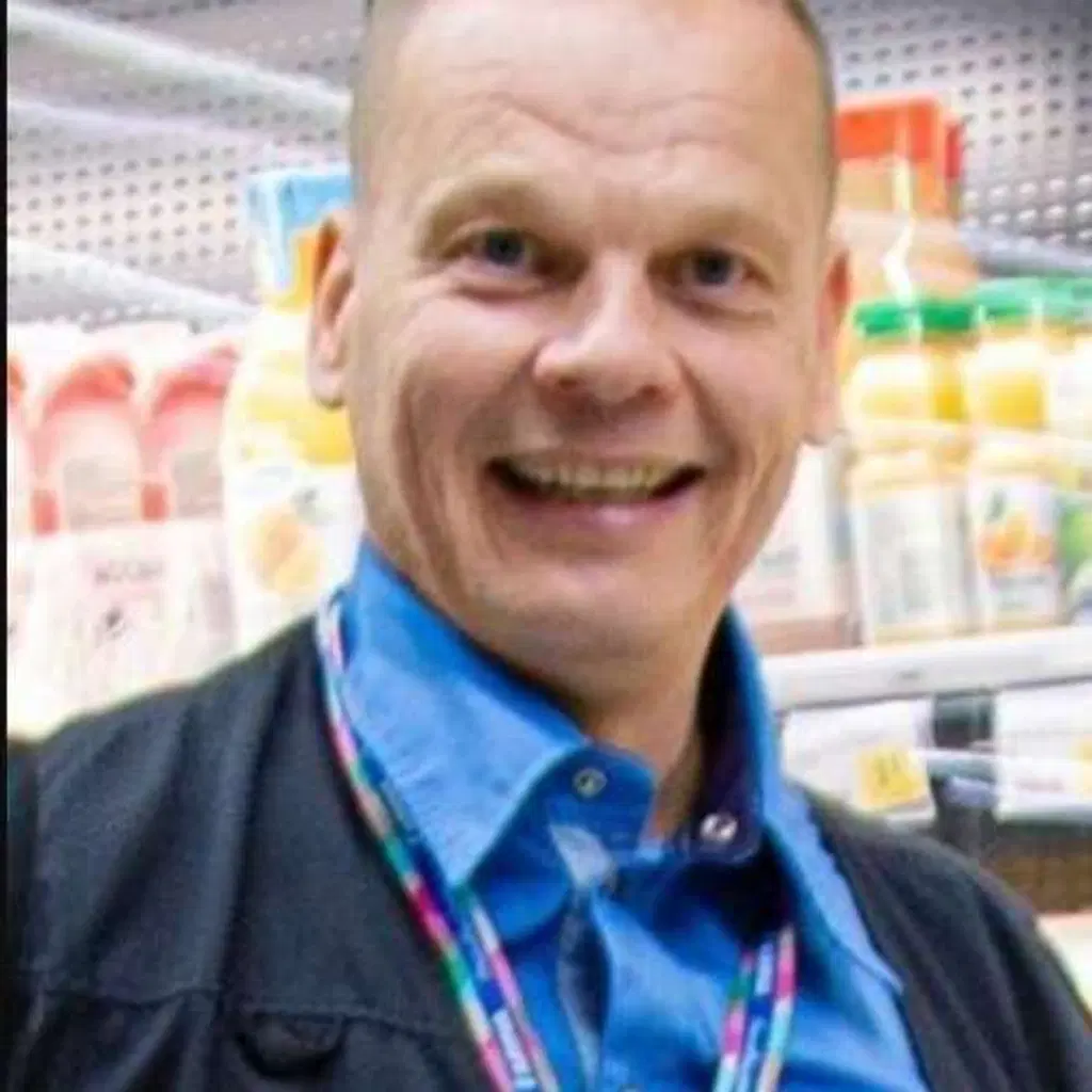 Mies katsoo hymyillen kameraan