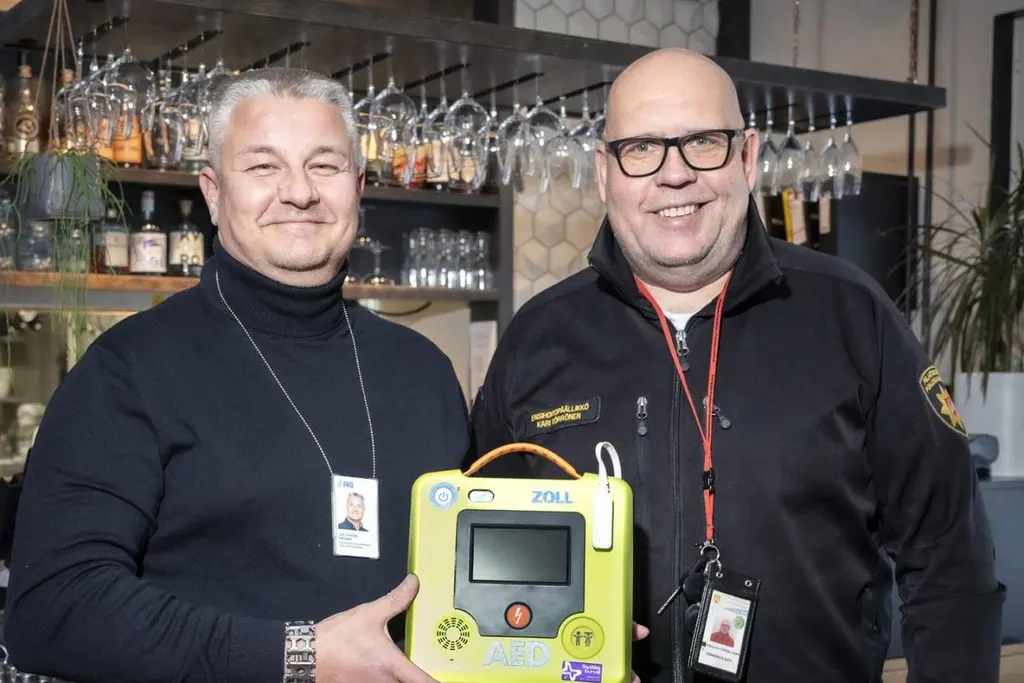 PKO:n työsuojelupäällikkö Jari Jurvanen (vas.) ja Pohjois-Karjalan pelastuslaitoksen ensihoitopäällikkö Kari Törrönen näyttävät miltä defibrillaattori näyttää.