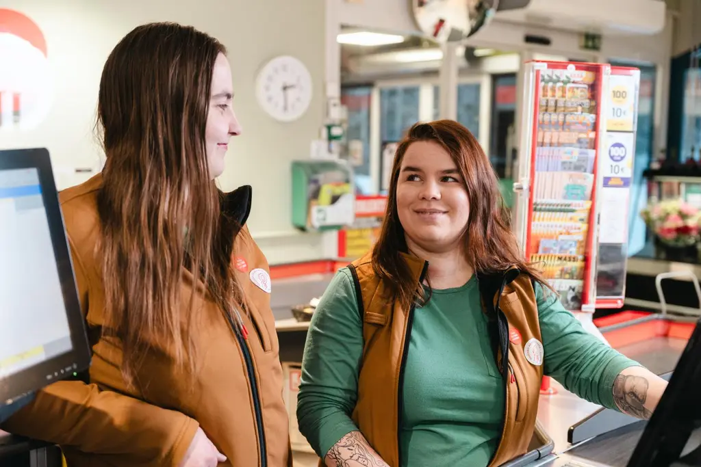 Kaksi nuorta Sale-työntekijää myymälän kassalla.