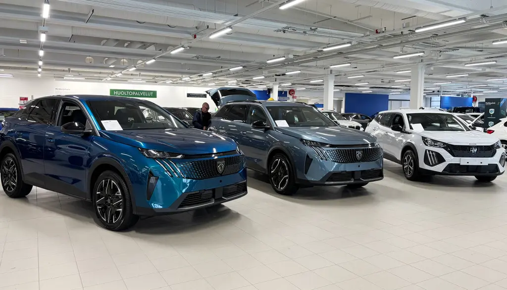 Sininen, harmaa ja valkoinen Peugeot kuvattuna edestä.