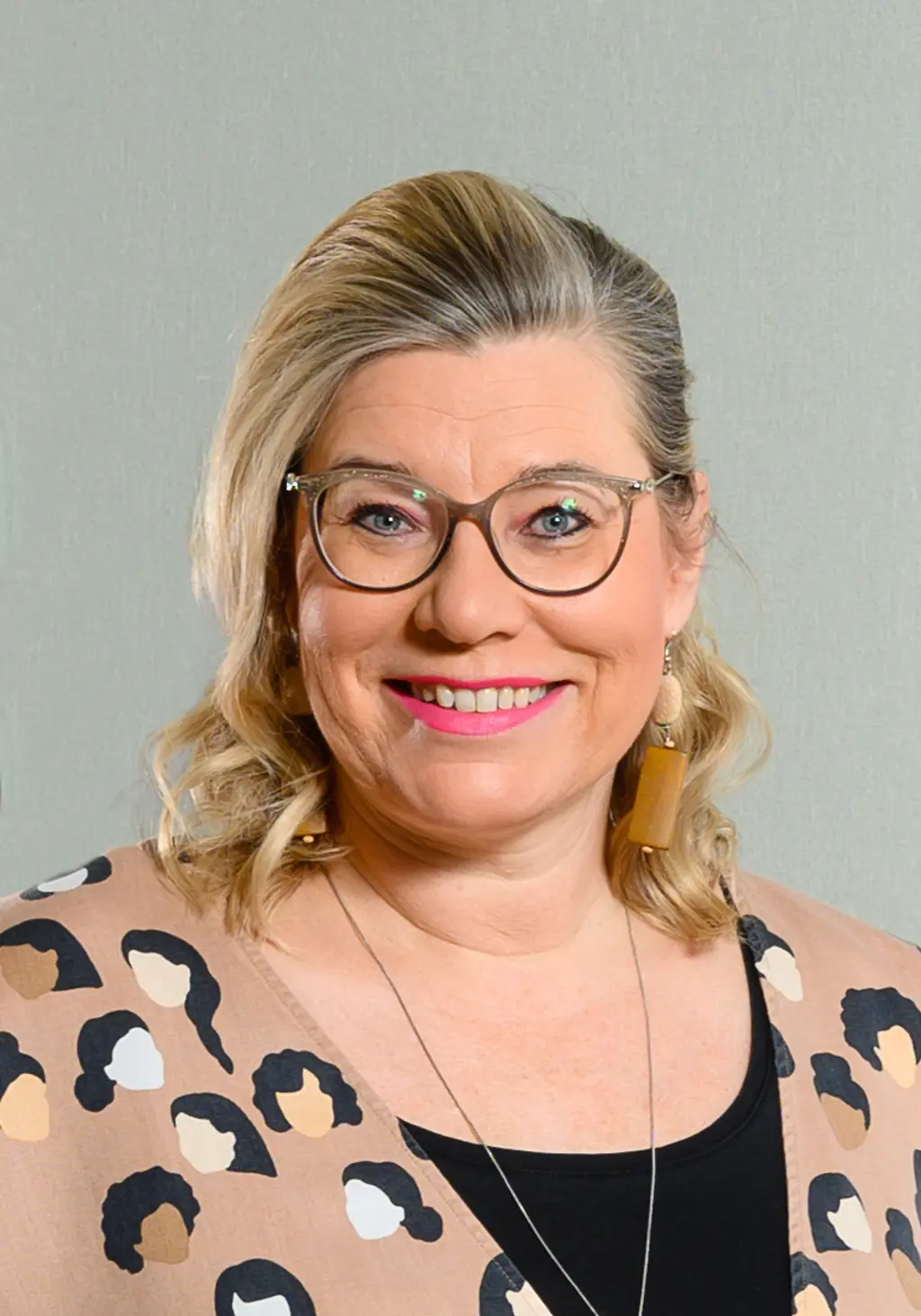 Nainen katsoo kameraan hymyillen