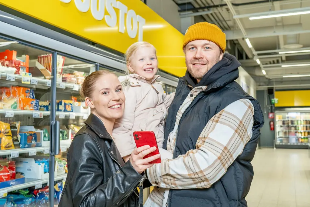 Perhe S-marketissa käyttämässä puhelimella S-mobiilia