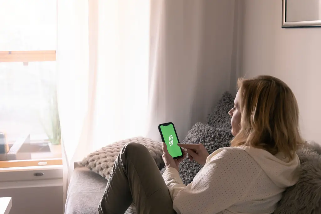 Asiakasomistaja selaa S-mobiilia kotisohvalla