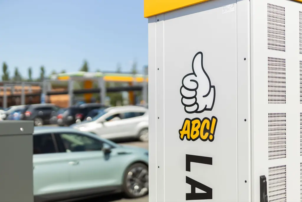 Etualalla oikealla on sähköauton latauspiste, takana autoja pysäköintialueella.