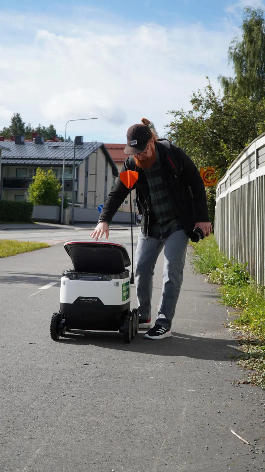 S-kaupat kuljetusrobotti Joensuun kadulla, mies avaa kuljetusluukun
