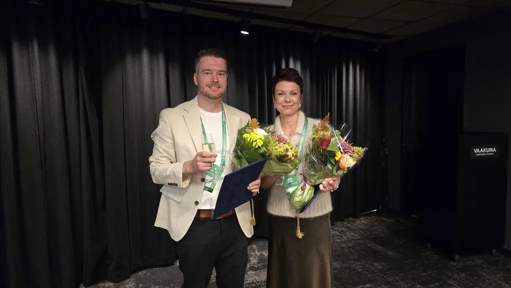 Palkitut Ässäpäälliköt Jenni Torkkel ja Pasi Salovaara poseeraavat kukkakimppujen kanssa.