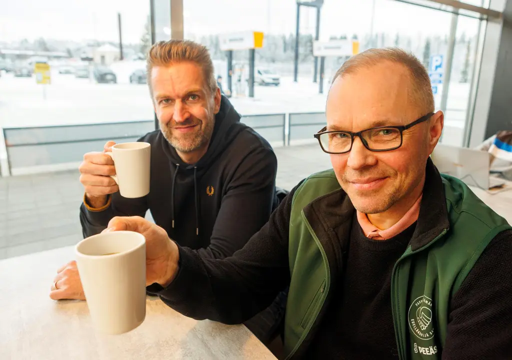 Kaksi miestä juo kahvia ABC-asemalla