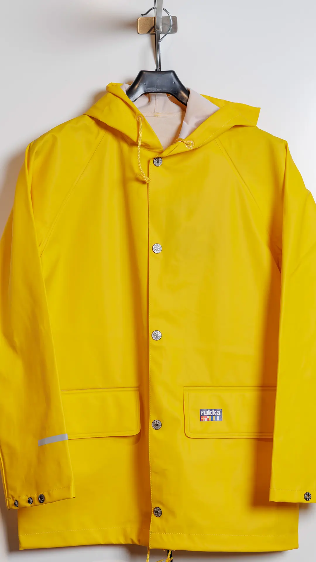 Henkarissa roikkuva keltainen Rukka-sadetakki.