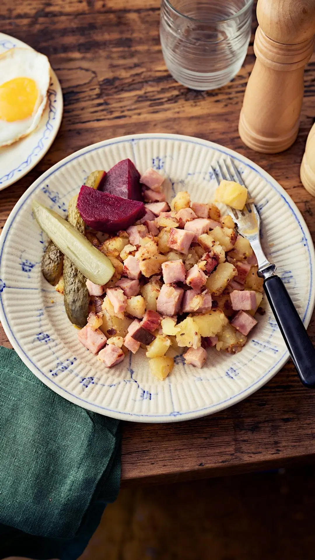 Joulukinkusta tehtyä pyttipannua lautasella, jossa myös säilykepunajuuria ja maustekurkkuja.