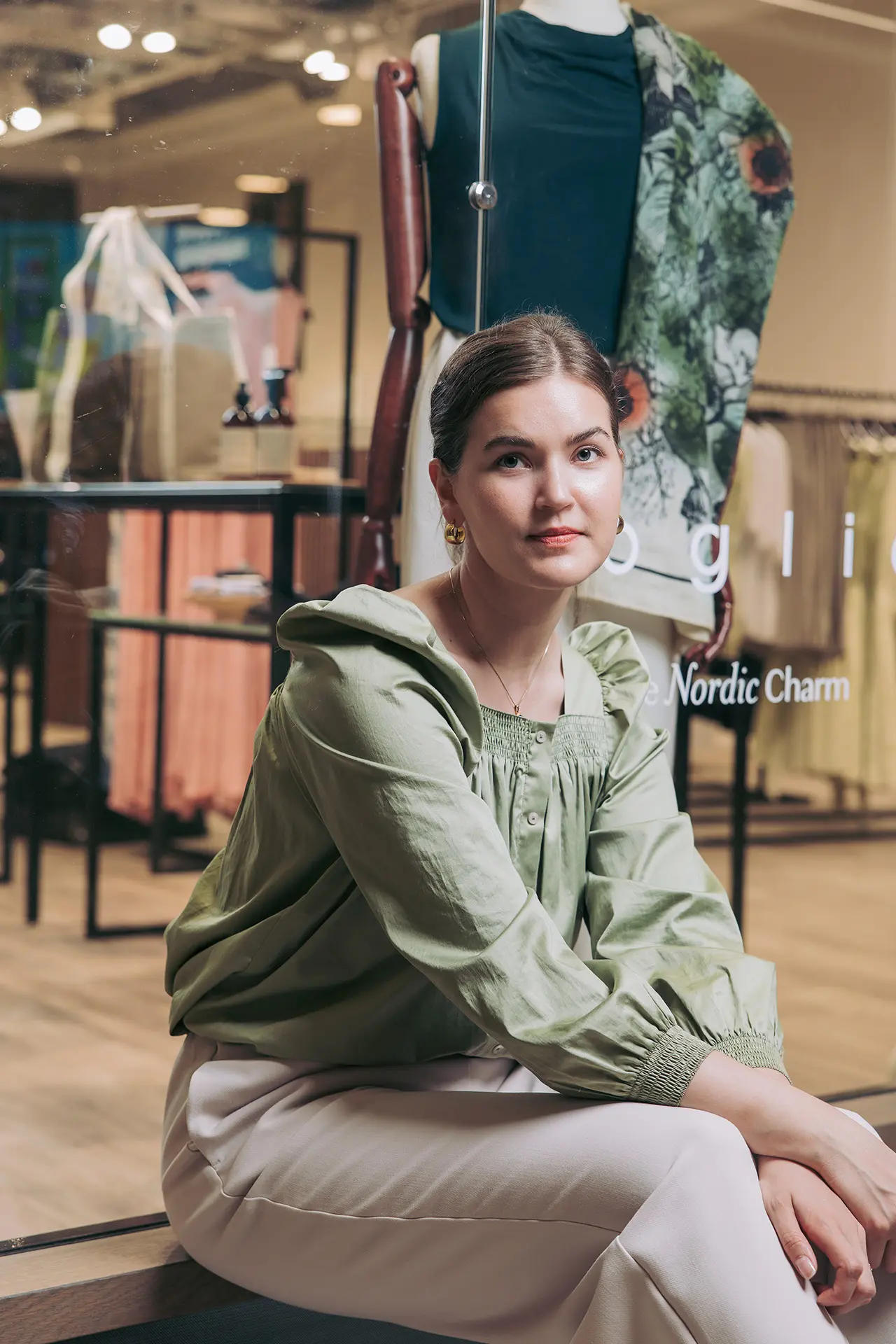 Katriina Virtanen istuu Voglian näyteikkunan edessä.