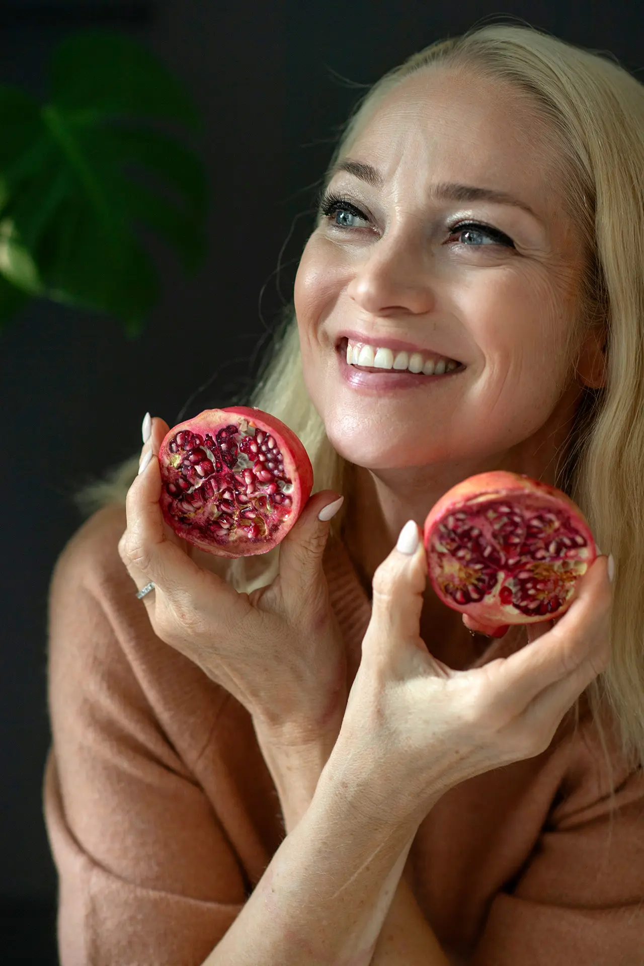 Pippa Laukka pitää kädessään granaattiomenaa