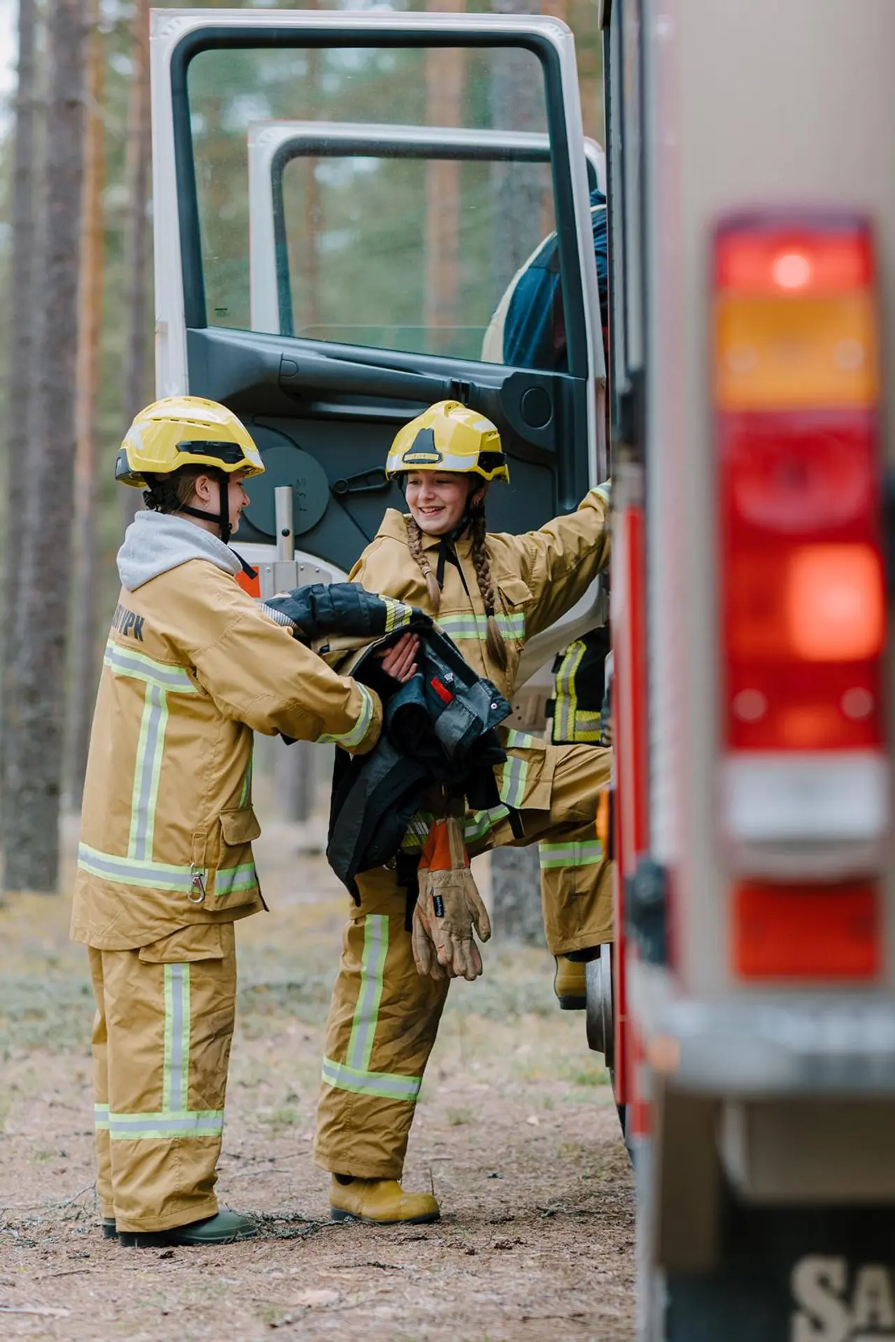 Sofia Lempiäinen ja Eeva Kosonen ottavat suojavarusteita autosta.
