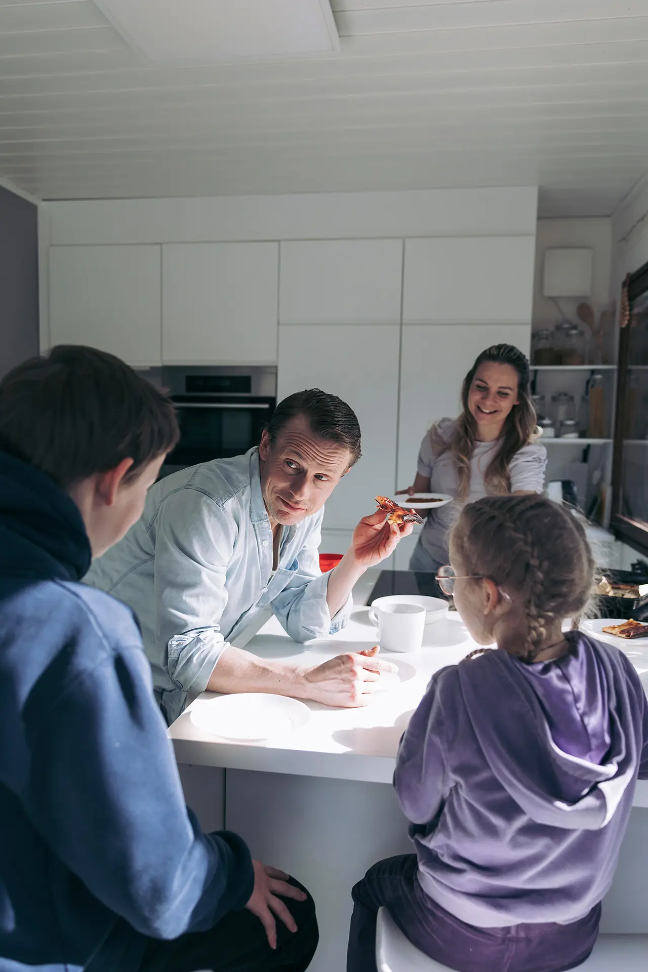 Konsta Hietanen perheineen kokoontuneena keittiöön syömään lettuja.