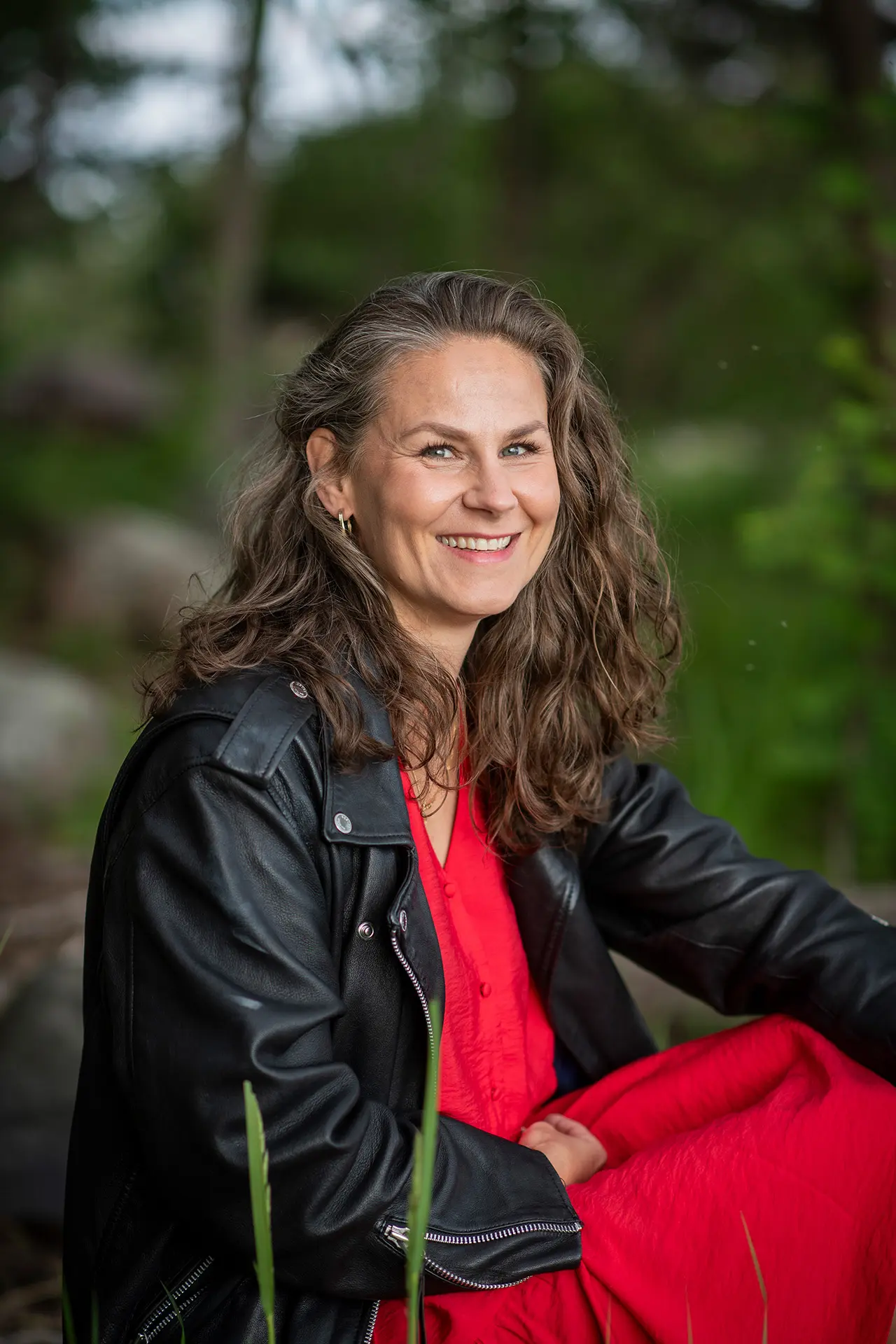 Elina Hovinen kuvattuna metsässä istumassa