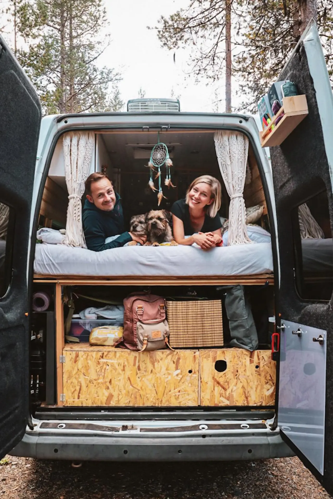 Pakettiauton takaovet on avattu. Ovien takaa paljastuu hyllymäinen säilytystila sekä sen päällä näkyy makuupatjojen päädyt. Craig ja Emma makaavat patjojen päällä ja katsovat kameraan.