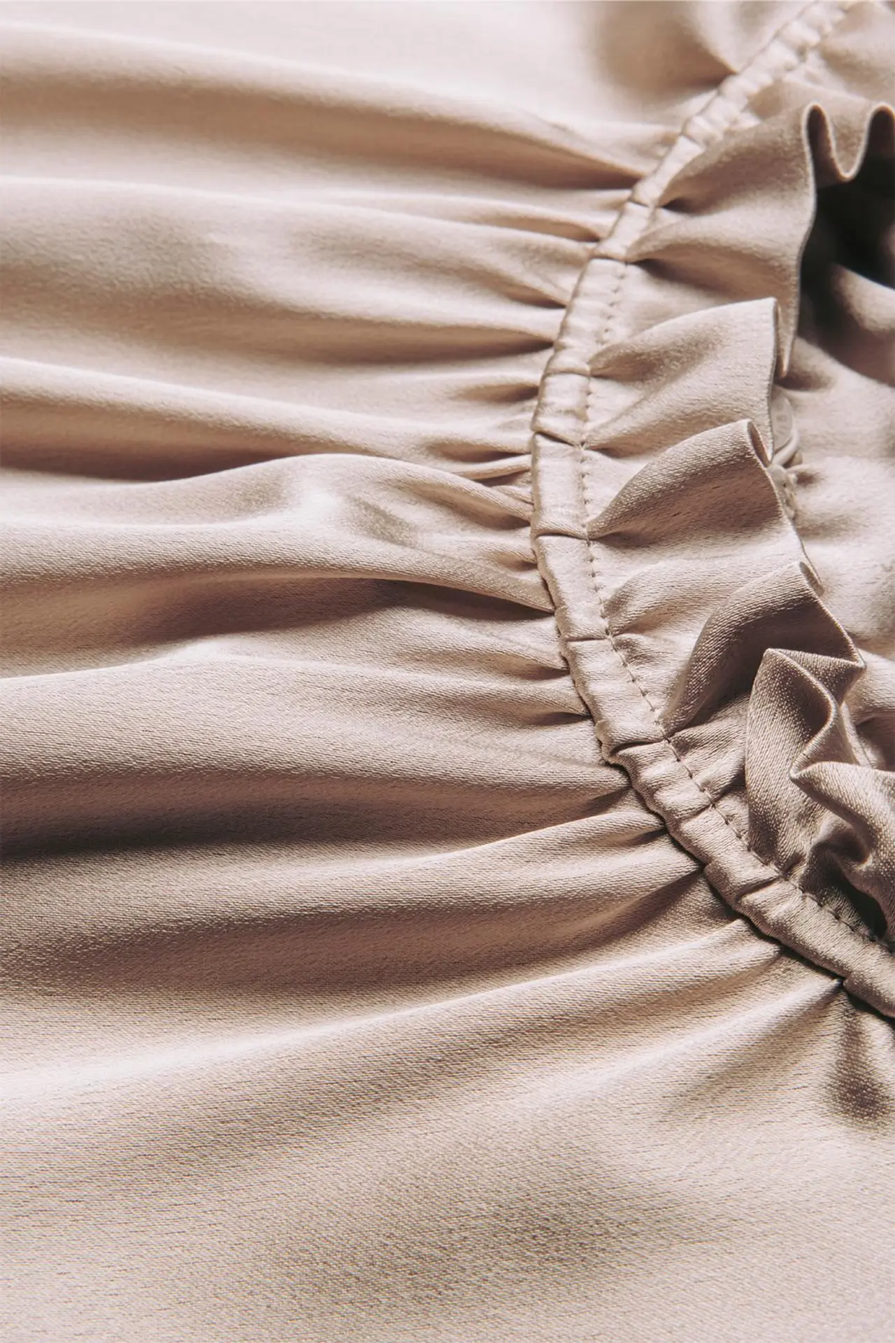 Yksityiskohta paidan rypytetystä kauluksesta.