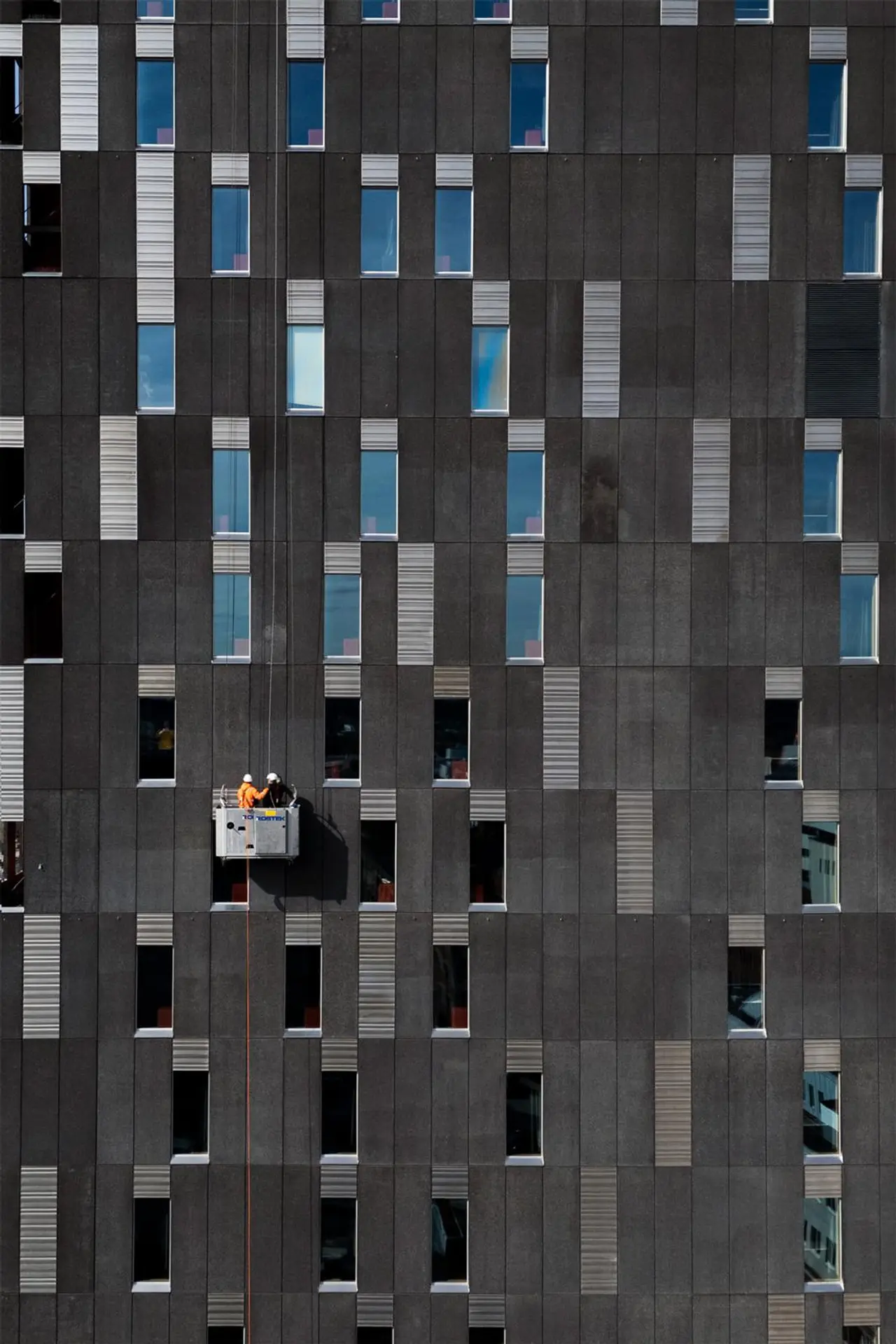 Siivousteknikot Jyrki Luomajärvi ja Petri Yli-Jaakkola korihississä pesemässä Torni-hotellin ikkunoita.