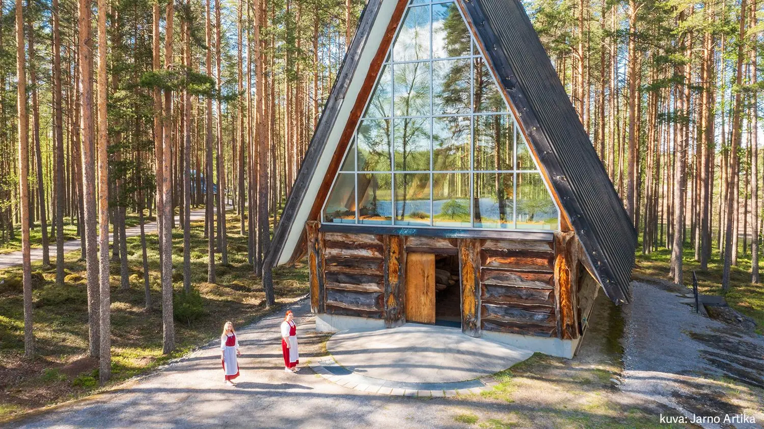 Kuvassa yksi Pielisen museon rakennusta ja kaksi työntekijää.