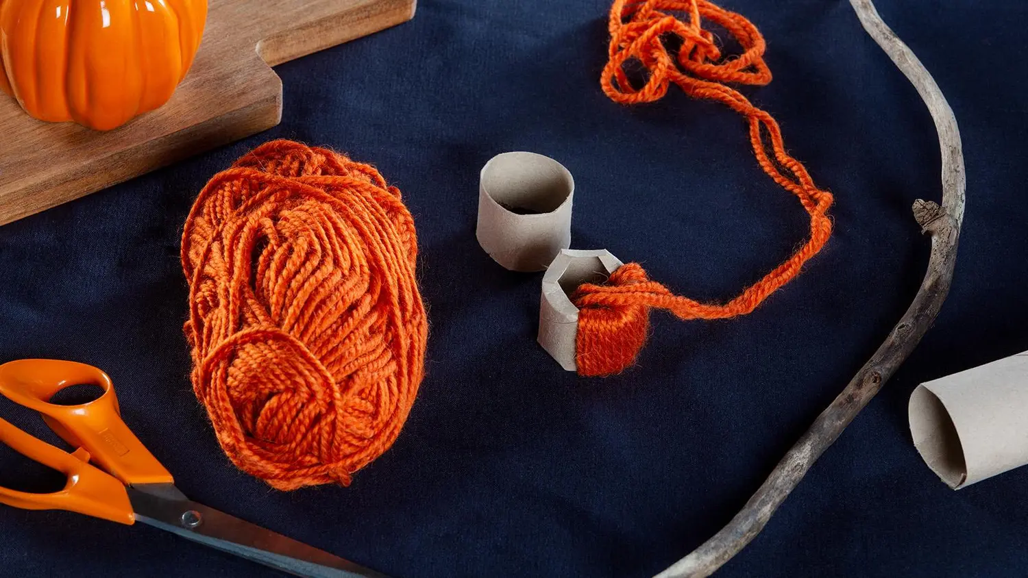 Langasta askarreltujen koristekurpitsojen tarvikkeet ja tekeillä oleva lankakurpitsa.