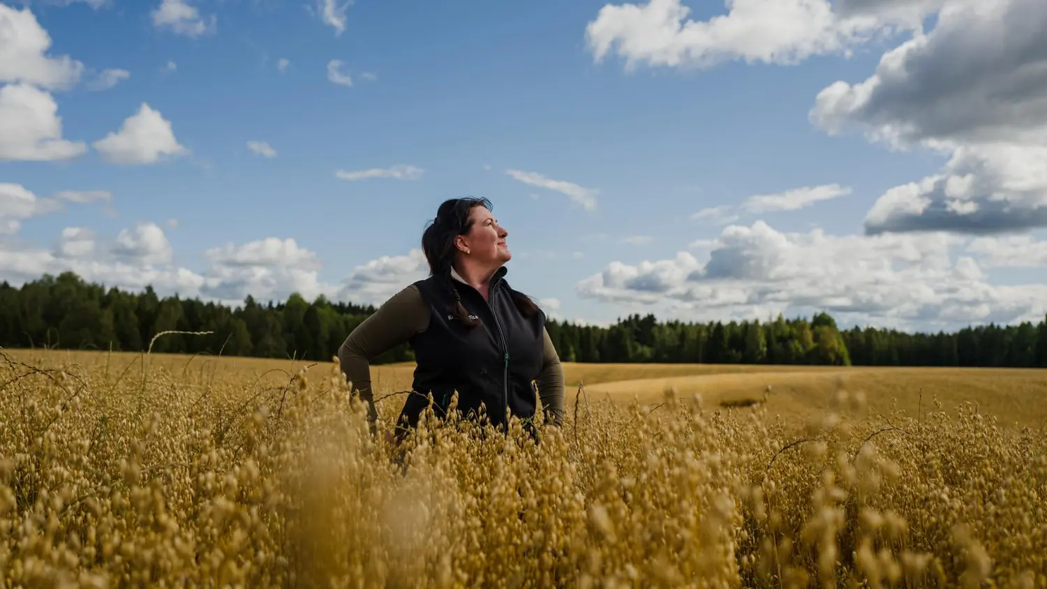 Terhi Kinnari seisoo kaurapellon keskellä