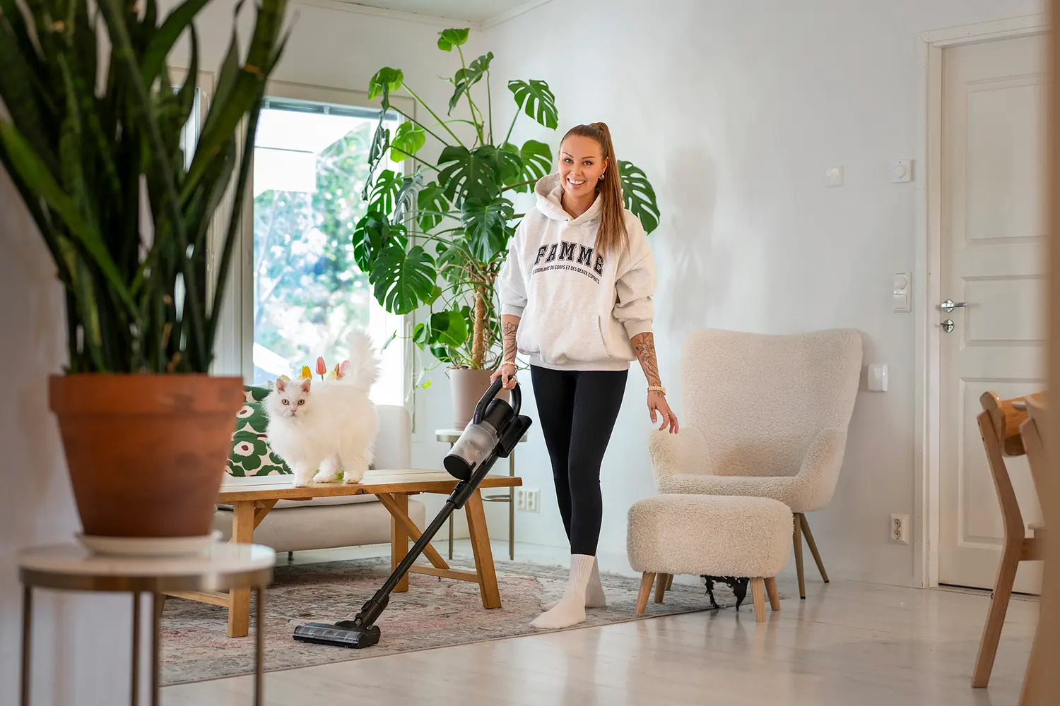 Sonia Nevalainen kotonaan imuri kädessä.