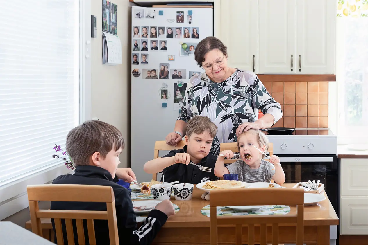 Anneli Makkonen keittiössä kolmen pojan kanssa.