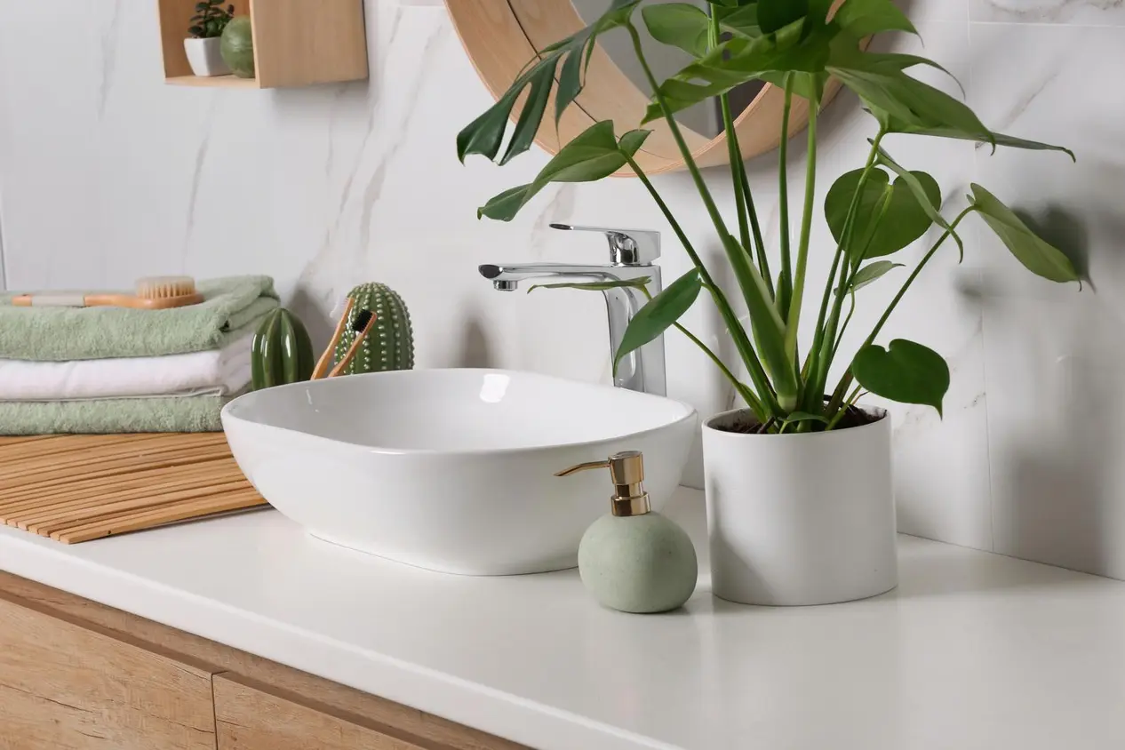 Kylpyhuoneen lavuaari, jonka vieressä käsipyyhkeitä ja sisustusesineitä