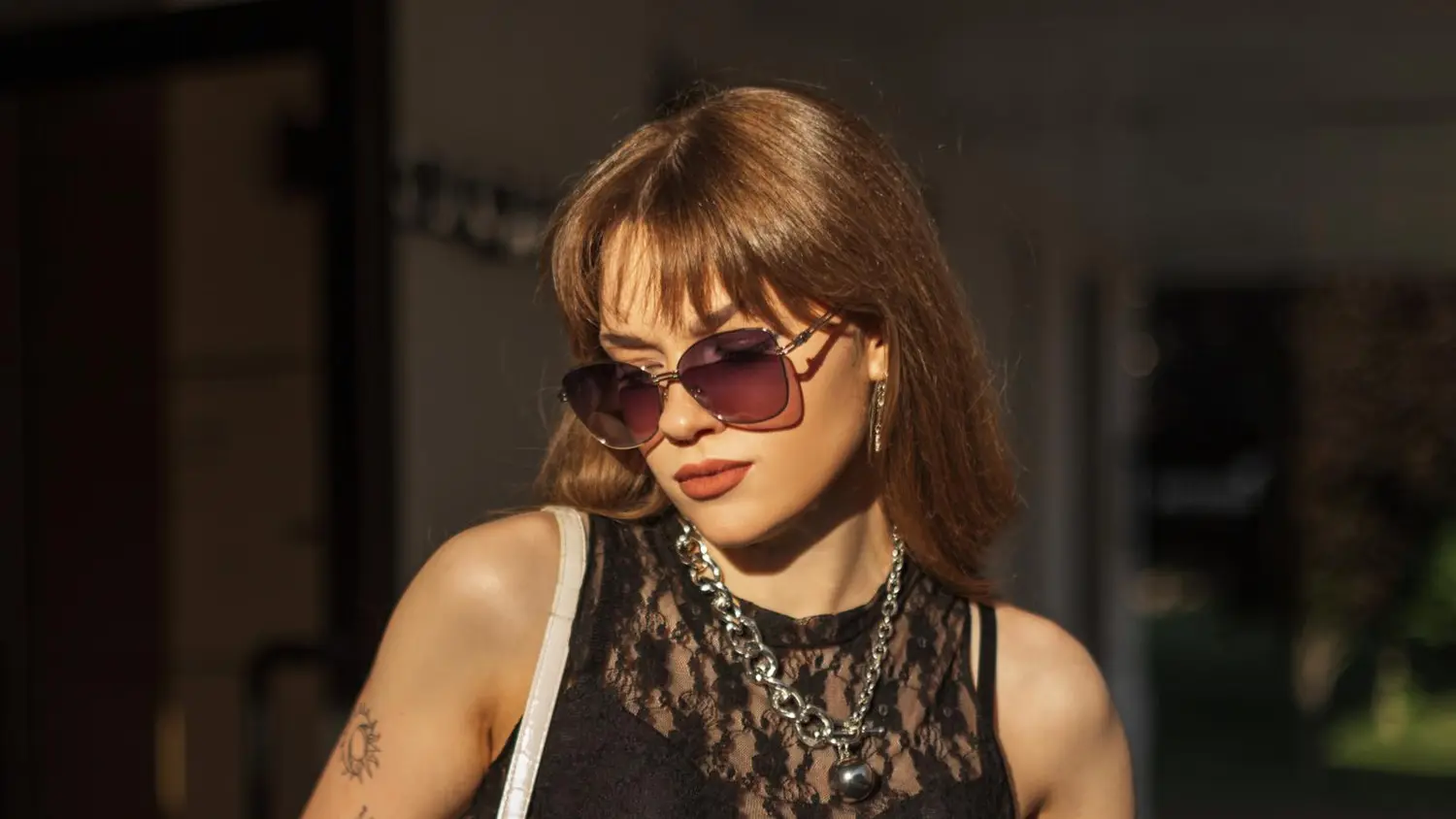 Nainen, jolla on aurinkolasit ja musta pitsitoppi päällä