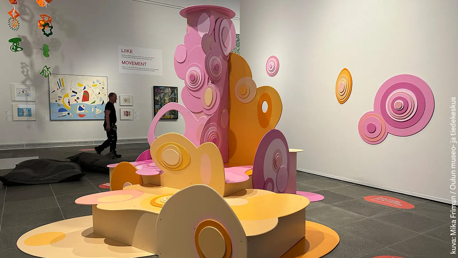 Anu Halmesmaan abstrakti taideteos, jossa vaaleanpunaisia ja vaaleankeltaisia ympyröitä.