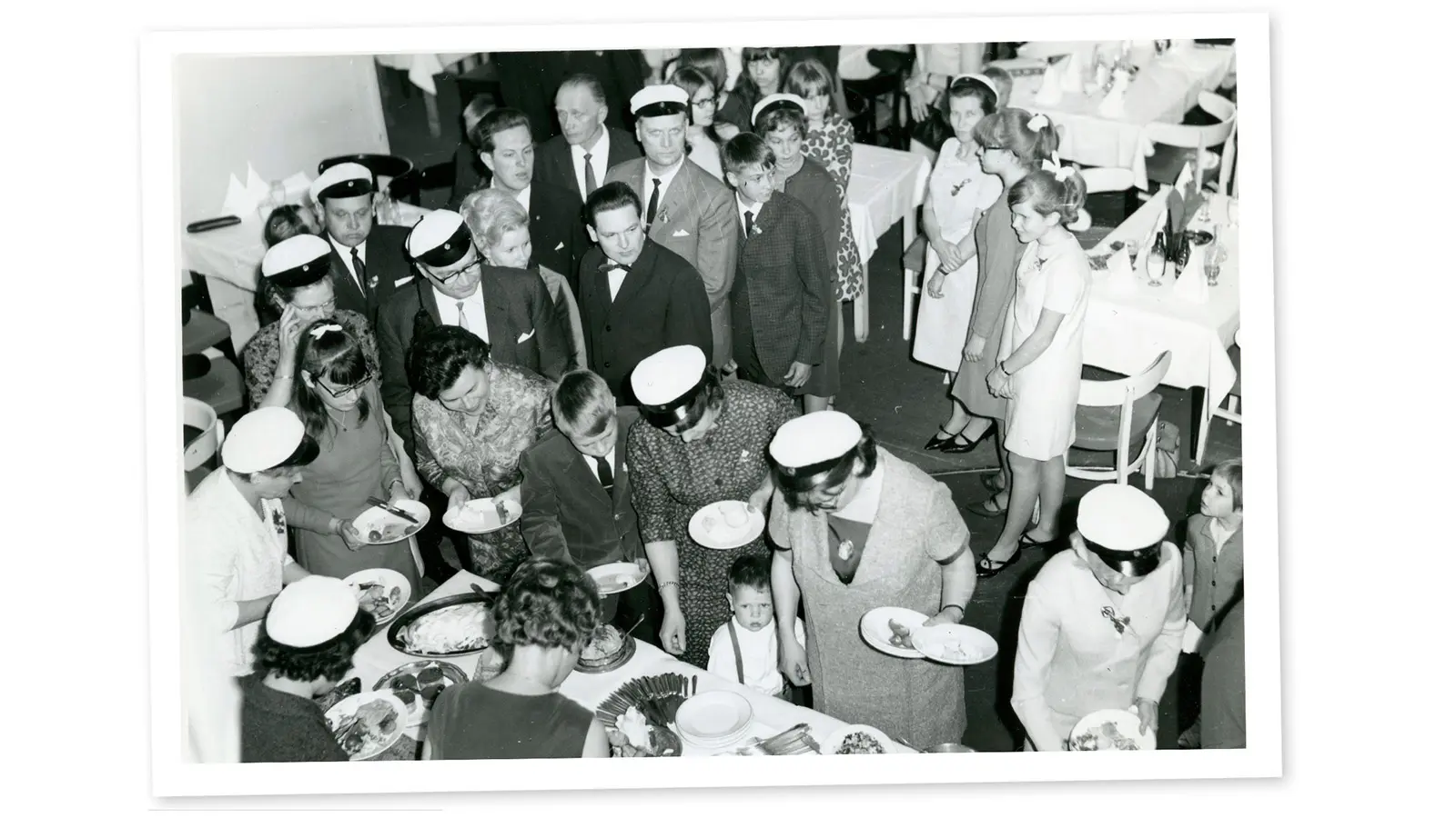 Historiakuva ylioppilaslakkipäisistä ruokailijoista