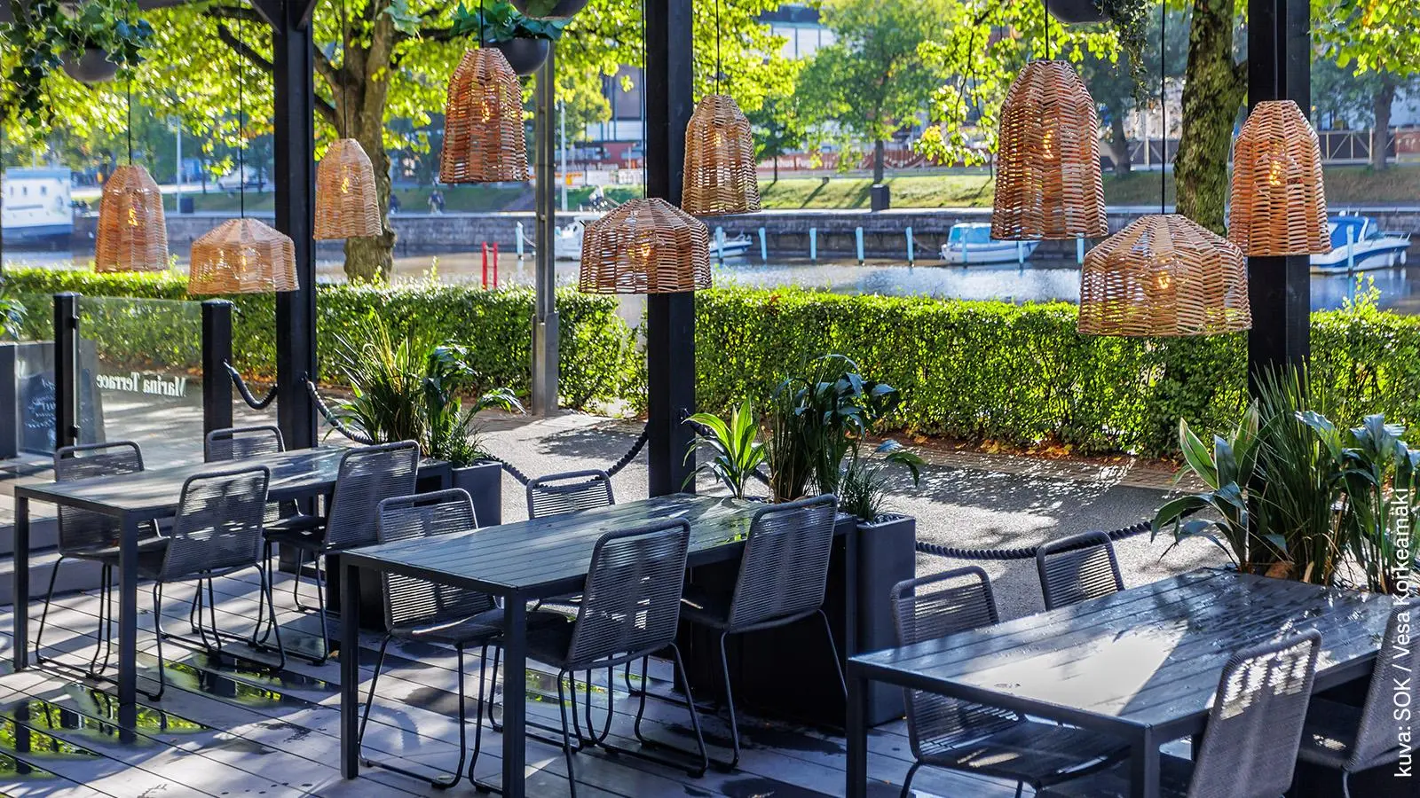 Grill It! Marinan terassi. Katosta roikkuu rottinkisia valaisimia.