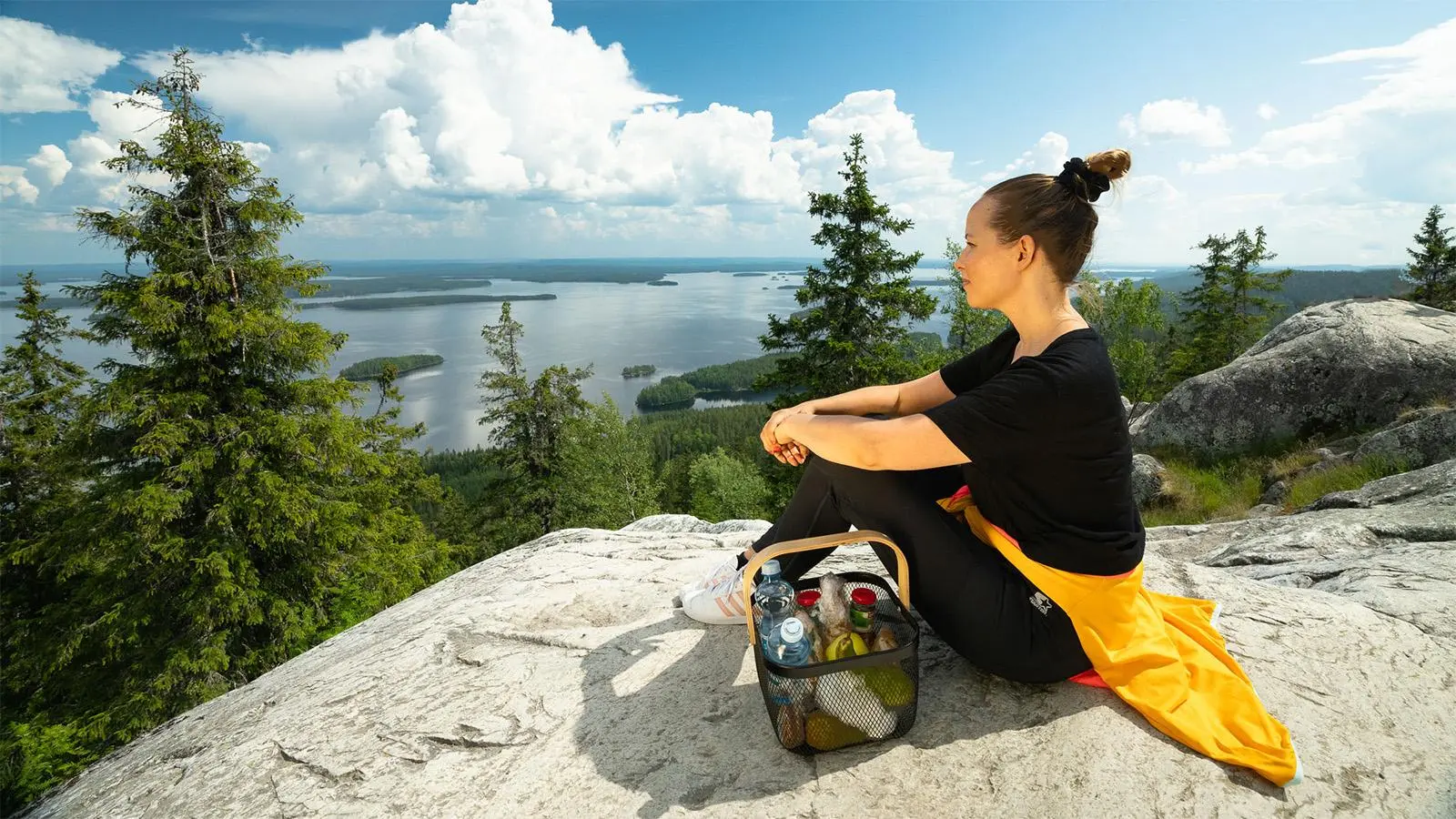 Nainen eväskorin kanssa Kolin kalliolla.