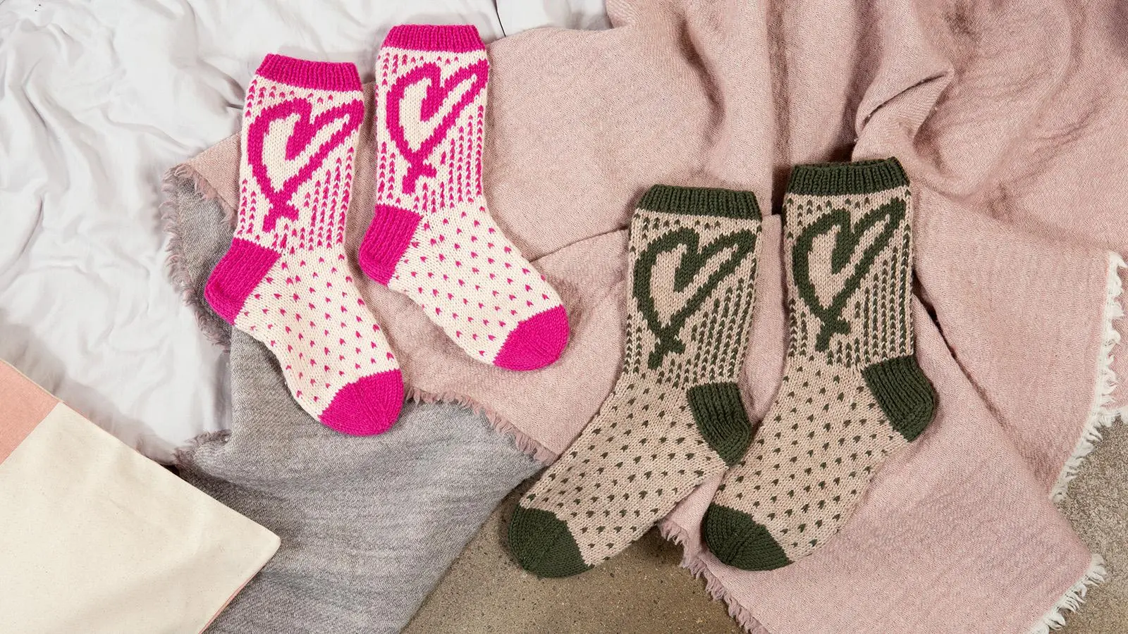 Kahdet sydänkuvioiset sukat vilttien päällä.