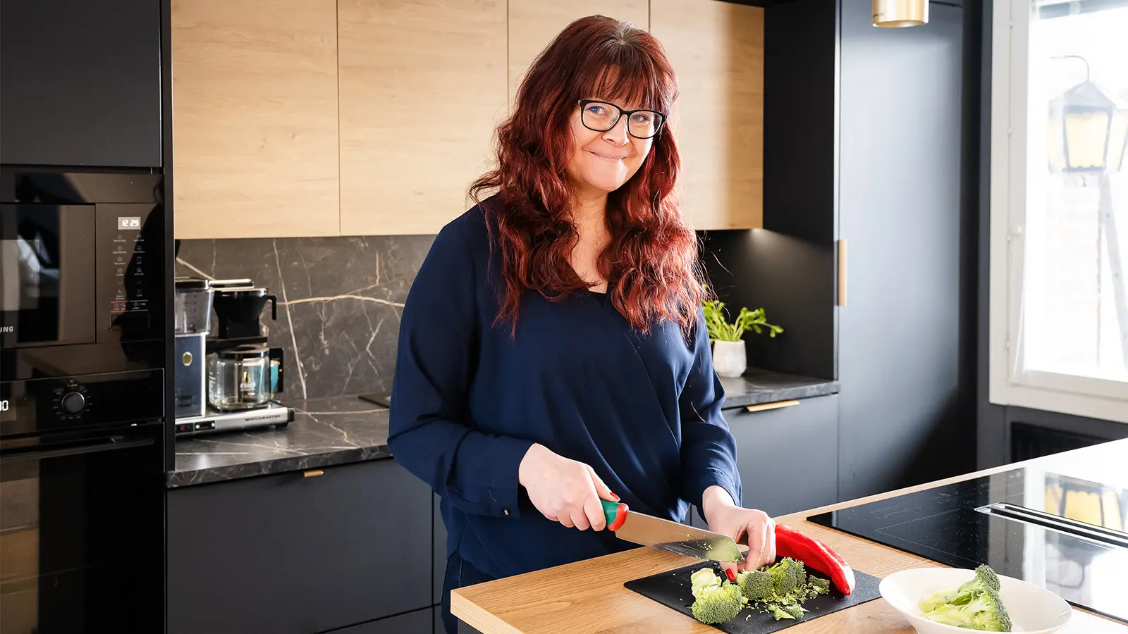 Maarit Rantaniitty pilkkoo parsakaalia keittiössä.